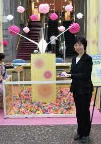 北とぴあのエントランスホールにて、千羽鶴を折る山崎たい子区議